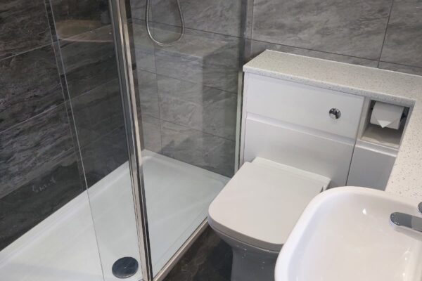 Shower room with Lakes walk-in shower panel, Atlanta gloss white grip furniture. Tiles from Minoli Tiles Oxford