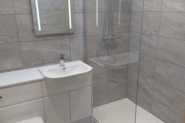 Fully tiled shower room with white gloss units